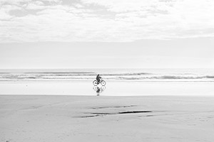 九十九里浜　波打ち際を自転車で走る人