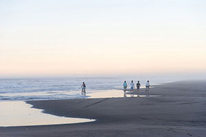 九十九里浜　夕焼けの中を友たち５人で歩く少年